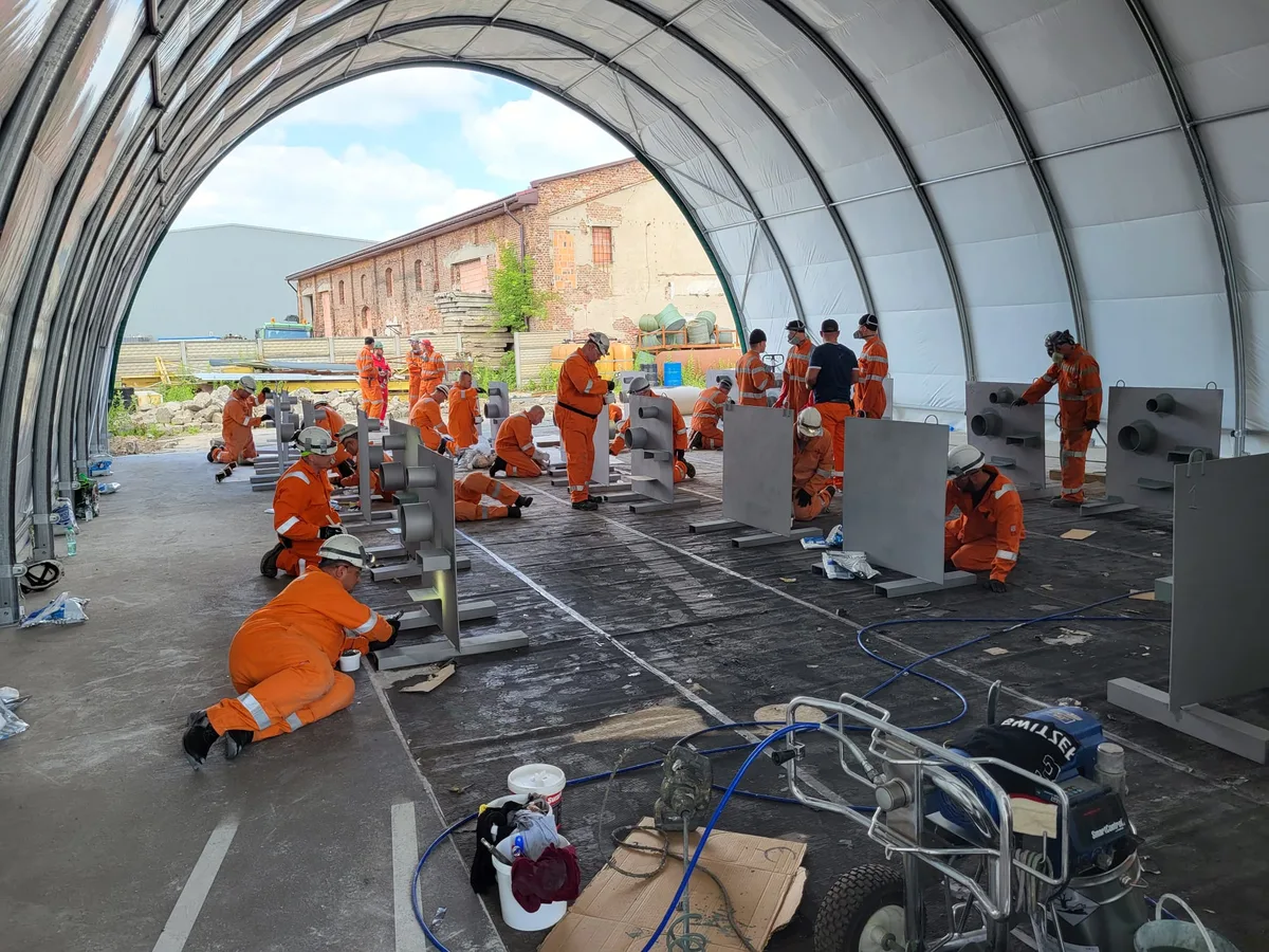 Szkolenie praktyczne — kursanci w kombinezonach