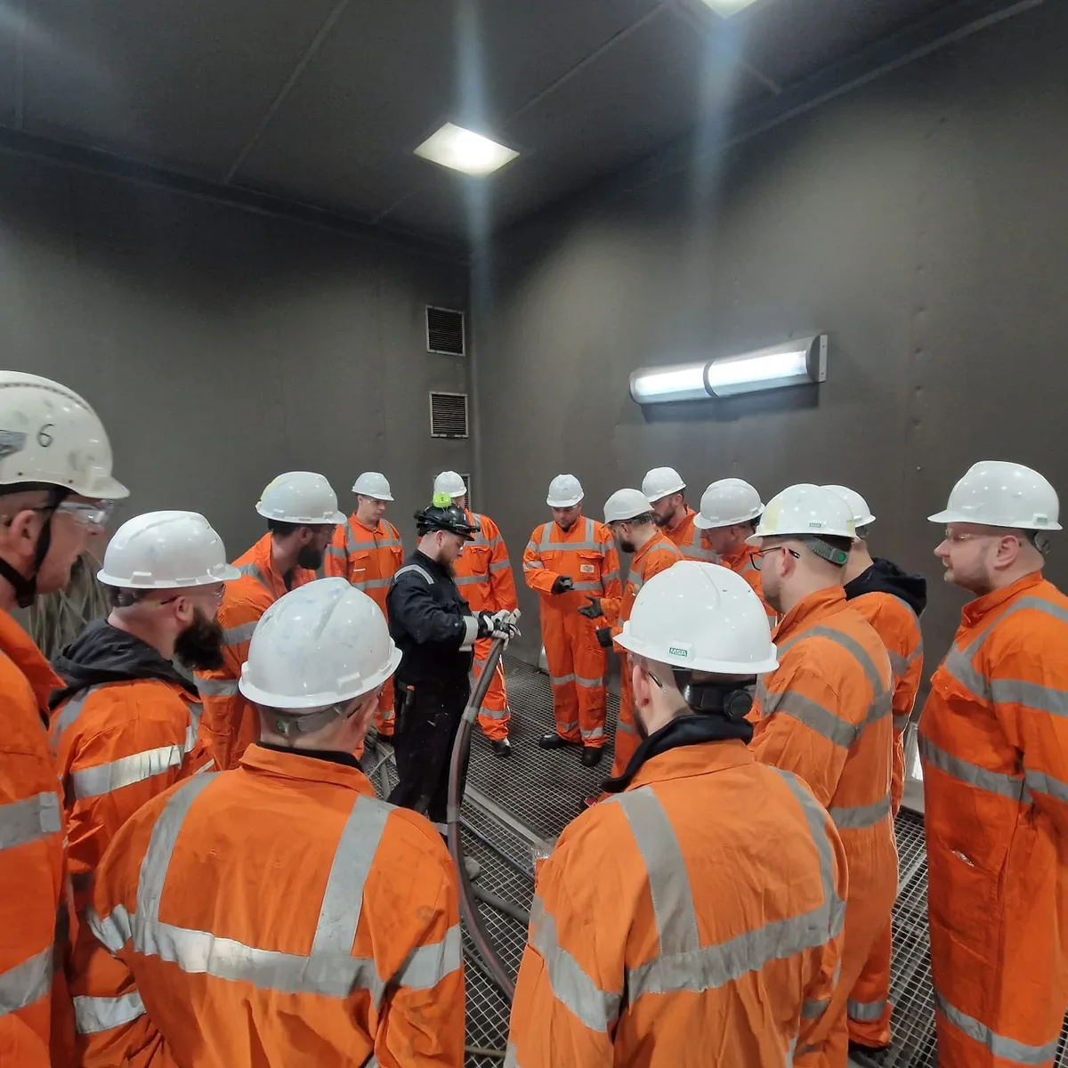 Szkolenie w komorze — kursanci w kaskach